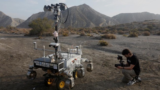A cameraman takes a video of a six-wheeled Mars rover prototype known as Charlie during a test by the European Space Agency (ESA), Airbus and other European partners, testing technologies and operational procedures for ESA's ExoMars Rosalind Franklin