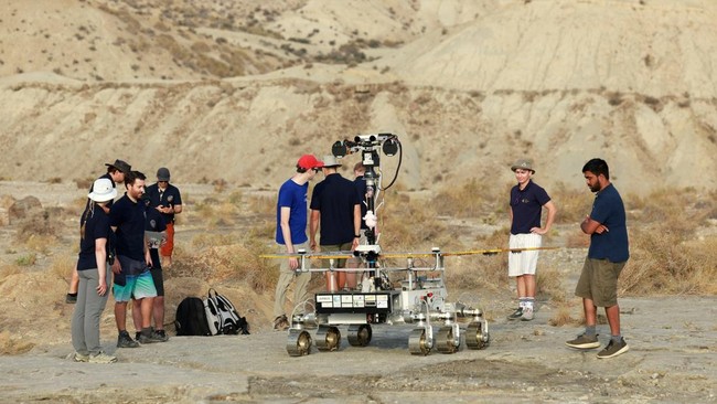Members of the testing team stand next to a six-wheeled Mars rover prototype known as Charlie during a test by the European Space Agency (ESA), Airbus and other European partners, testing technologies and operational procedures for ESA's ExoMars Rosa