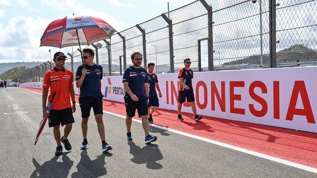 Pembalap Honda Team Asia Veda Pratama (kiri) berjalan keliling sirkuit bersama rekan timnya saat mengikuti sesi pengenalan lintasan (riders track familiarisation) jelang balapan MotoGP di Sirkuit Internasional Pertamina Mandalika, KEK Mandalika, Kuta
