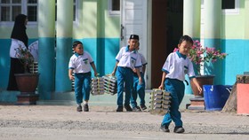 Sejumlah siswa membawa ompreng Makan Bergizi Gratis (MBG) di kompleks Madrasah Ibtidayyah Negeri (MIN) 11 Aceh Barat Desa Kuta Padang, Johan Pahlawan, Aceh Barat, Aceh, Senin (21/9/2026). Menteri Keuangan Suahasil Nazara mengatakan realisasi anggaran
