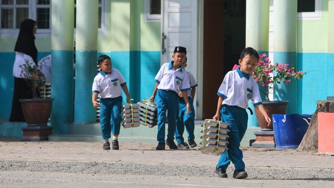 Sejumlah siswa membawa ompreng Makan Bergizi Gratis (MBG) di kompleks Madrasah Ibtidayyah Negeri (MIN) 11 Aceh Barat Desa Kuta Padang, Johan Pahlawan, Aceh Barat, Aceh, Senin (21/9/2026). Menteri Keuangan Suahasil Nazara mengatakan realisasi anggaran