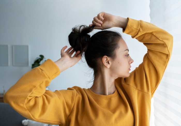 Rambut panjang dapat memindahkan minyak dan residu produk perawatan ke kulit wajah. Mengikat rambut sebelum olahraga membantu mengurangi kontak tersebut sekaligus menjaga wajah tetap nyaman./ Foto: magnific.com