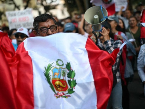 A demonstrator shows a national flag during a protest over alleged fraud following the results of the presidential election in front of the National Jury of Elections (JNE) headquarters in Lima on April 14, 2026. Ultra-conservative candidate Rafael L