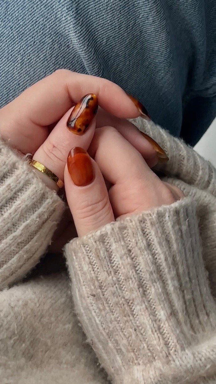 Pumpkin spice jelly nails mengandalkan warna transparan yang memberikan efek kuku seperti kaca berwarna. Nuansa oranye dan coklat tipis menciptakan manikur yang segar, modern, dan playful./ Foto: instagram.com/swaknails