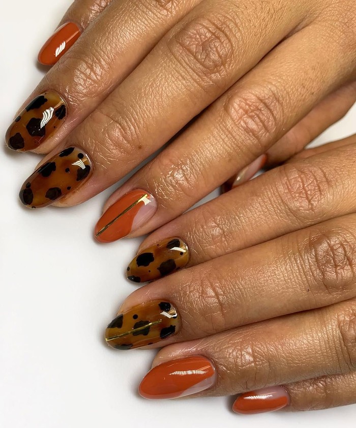 Pumpkin tortoiseshell memadukan warna khas musim gugur dengan motif menyerupai cangkang kura-kura. Tambahan aksen foil emas membuat desain kuku terlihat lebih mewah dan artistik./ Foto: instagram.com/nailsbycanishiea