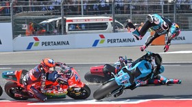 Pembalap CFMOTO Power Electronics Aspar Team David Alonso (kanan) terpental usai bersenggolan dengan rekan satu timnya, Daniel Holgado (tidak terlihat), sementara pembalap QJMOTOR JP Financial  MSI Ivan Ortola (kiri) melaju saat balapan Moto2 Pertami