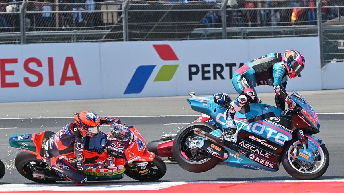 Pembalap CFMOTO Power Electronics Aspar Team David Alonso (kanan) terpental usai bersenggolan dengan rekan satu timnya, Daniel Holgado (tidak terlihat), sementara pembalap QJMOTOR JP Financial  MSI Ivan Ortola (kiri) melaju saat balapan Moto2 Pertami