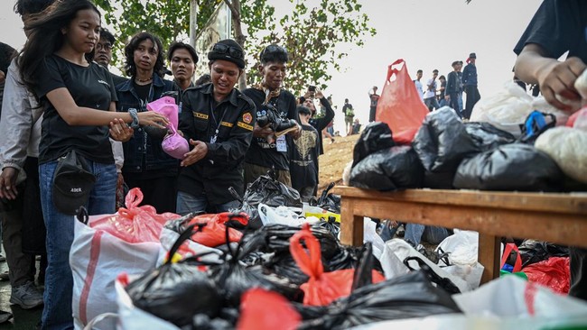 Penonton menyerahkan beras sebagai tiket masuk konser grup musik Dongker di Plaza Kalibaru, Jakarta, Sabtu (10/10/2026). Dalam konser bertajuk 'Melankolia' tersebut, Dongker membawakan sejumlah lagu di antaranya Metafora Berpelukan, Disarankan di Ban