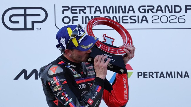 MotoGP - Indonesian Grand Prix - Mandalika International Street Circuit, Mandalika, Indonesia - October 11, 2026 Aprilia Racing's Marco Bezzecchi celebrates on the podium with a trophy after winning the MotoGP race REUTERS/Willy Kurniawan