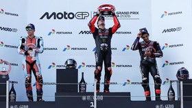 MotoGP - Indonesian Grand Prix - Mandalika International Street Circuit, Mandalika, Indonesia - October 11, 2026 Aprilia Racing's Marco Bezzecchi celebrates on the podium with a trophy after winning the MotoGP race with second place Trackhouse MotoGP