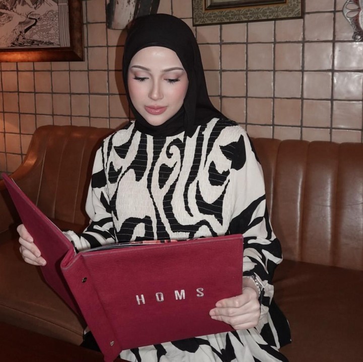 <p>Dalam salah satu foto, kakak ipar selebgram Fadil Jaidi ini tampak duduk di sofa sambil memegang buku menu berwarna merah. Perempuan kelahiran 30 Juli 2003 ini tampak sedang melihat menu yang ada di resto tersebut. (Foto: @miskashf).</p>
