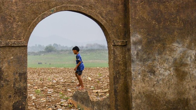 Seorang anak bermain diantara bangunan masjid yang muncul kembali di tepian Waduk Jatigede yang surut di Desa Sukamenak, Kecamatan Darmaraja, Kabupaten Sumedang, Jawa Barat, Minggu (11/10/2026). Berdasarkan data dari Badan Penanggulangan Bencana Daer