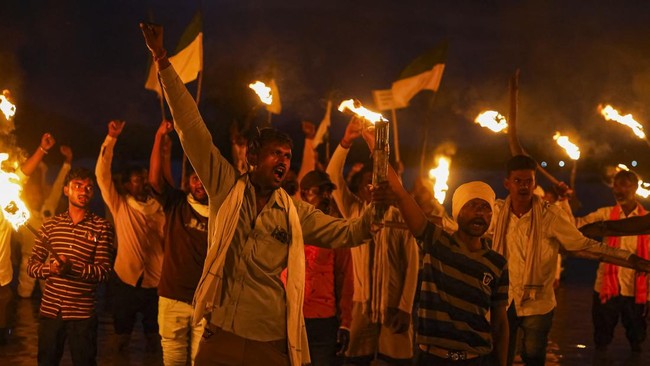 People from families affected by the Ken-Betwa River Linking Project hold torches and raise slogans demanding compensation and proper rehabilitation during a protest near the Majhgawan Dam on the Ken River in Ajaygarh, Madhya Pradesh, India, Septembe