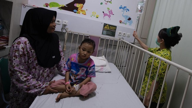 Orang tua dari pasien anak penderita ISPA menunggu anaknya yang menjalani perawatan di Rumah Sakit Charitas Palembang.