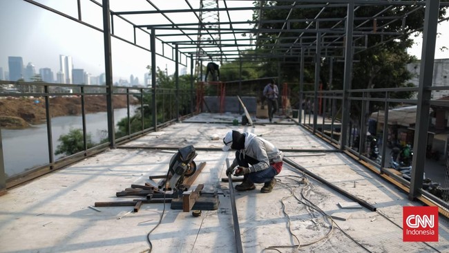 Pekerja menggarap proyek pembangunan ruang publik Taman Jati Pinggir di sepanjang aliran Kanal Banjir Barat (KBB), Petamburan, Jakarta, Selasa, (13/10/2026). CNN Indonesia/Adhi Wicaksono