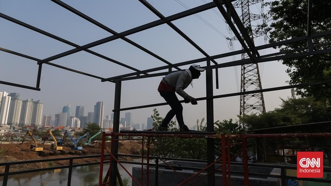 Pekerja menggarap proyek pembangunan ruang publik Taman Jati Pinggir di sepanjang aliran Kanal Banjir Barat (KBB), Petamburan, Jakarta, Selasa, (13/10/2026). CNN Indonesia/Adhi Wicaksono