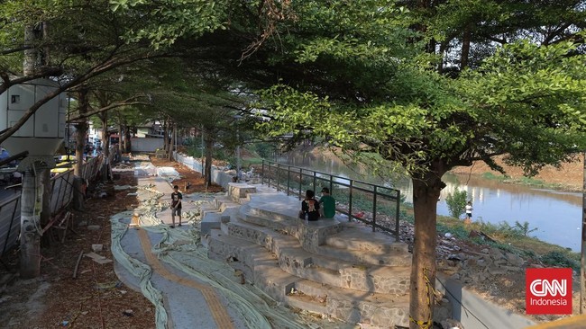 Pekerja menggarap proyek pembangunan ruang publik Taman Jati Pinggir di sepanjang aliran Kanal Banjir Barat (KBB), Petamburan, Jakarta, Selasa, (13/10/2026). CNN Indonesia/Adhi Wicaksono