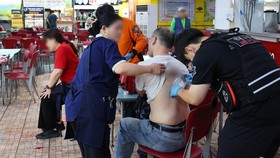 Rescue workers treat victims at the scene after a stabbing incident at a supermarket in Incheon on October 13, 2026. One person was in cardiac arrest and several others wounded in a stabbing incident on October 13, at a supermarket in South Korea's c