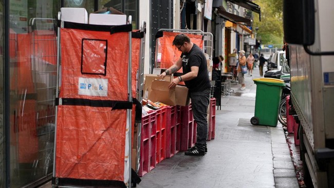 An employee fills boxes of perished goods outside an Intermarche supermarket in Paris the day after a cyberattack targeted refrigeration systems at French supermarket chains, causing food losses and fires at several stores, France, October 13, 2026.