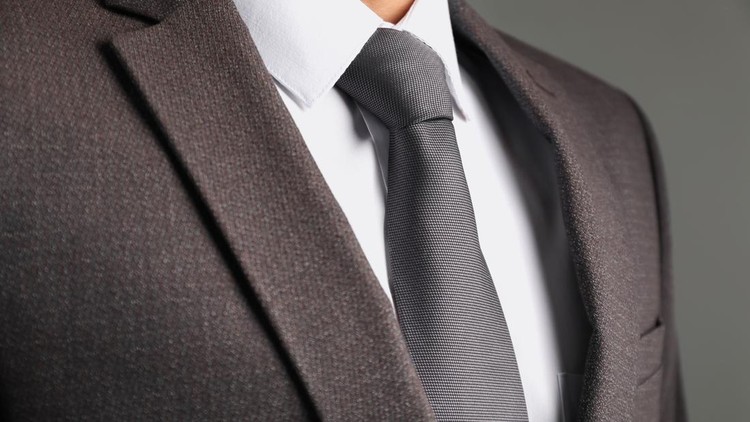 Man in suit with stylish necktie on grey background&comma; closeup
