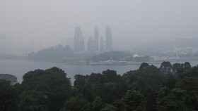 Haze shrouds a luxury condominium at Keppel Bay as smoke from regional forest fires reduces visibility across the island city-state of Singapore, October 14, 2026. REUTERS/Suhaimi Abdullah