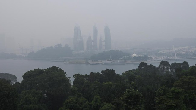 Haze shrouds a luxury condominium at Keppel Bay as smoke from regional forest fires reduces visibility across the island city-state of Singapore, October 14, 2026. REUTERS/Suhaimi Abdullah