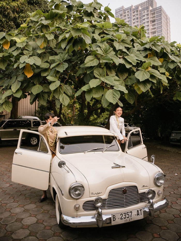 Dikta menaiki mobil klasiknya ke tempat acara akad nikah. Setelah resmi menjadi pasangan suami istri, keduanya pun berfoto ria bahagia dengan mobil klasik tersebut.&nbsp;(Foto: Instagram.com/dikta/rchelcia)