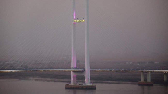 The newly opened New Yalu River Bridge, which connects China's Dandong New Zone and North Korea's Sinuiju, is illuminated at sunset, as seen from Dandong, Liaoning Province, China, October 15, 2026. REUTERS/Florence Lo