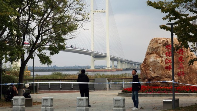 Security personnel keep watch at a cordoned-off waterfront before the opening ceremony for the New Yalu River Bridge, which connects Chinas Dandong New Zone and North Koreas Sinuiju, in Dandong, Liaoning province, China October 15, 2026. REUTERS/Flor