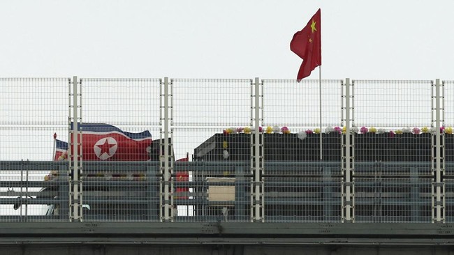 A truck adorned with North Korean flags enters the Chinese side of the newly opened New Yalu River Bridge, which connects Chinas Dandong New Zone and North Koreas Sinuiju, in Dandong, Liaoning province, China October 15, 2026. REUTERS/Florence Lo