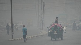 People wearing protective masks ride on a three-wheeled vehicle through a road as haze from wildfires shrouds the area in Palembang, South Sumatra province, Indonesia, October 15, 2026. REUTERS/Abriansyah Liberto