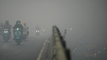 Motorists wearing protective masks ride on a bridge as haze from wildfires shrouds the area in Palembang, South Sumatra province, Indonesia, October 15, 2026. REUTERS/Abriansyah Liberto