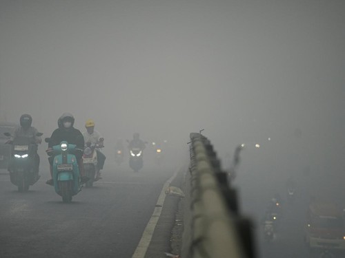 Motorists wearing protective masks ride on a bridge as haze from wildfires shrouds the area in Palembang, South Sumatra province, Indonesia, October 15, 2026. REUTERS/Abriansyah Liberto