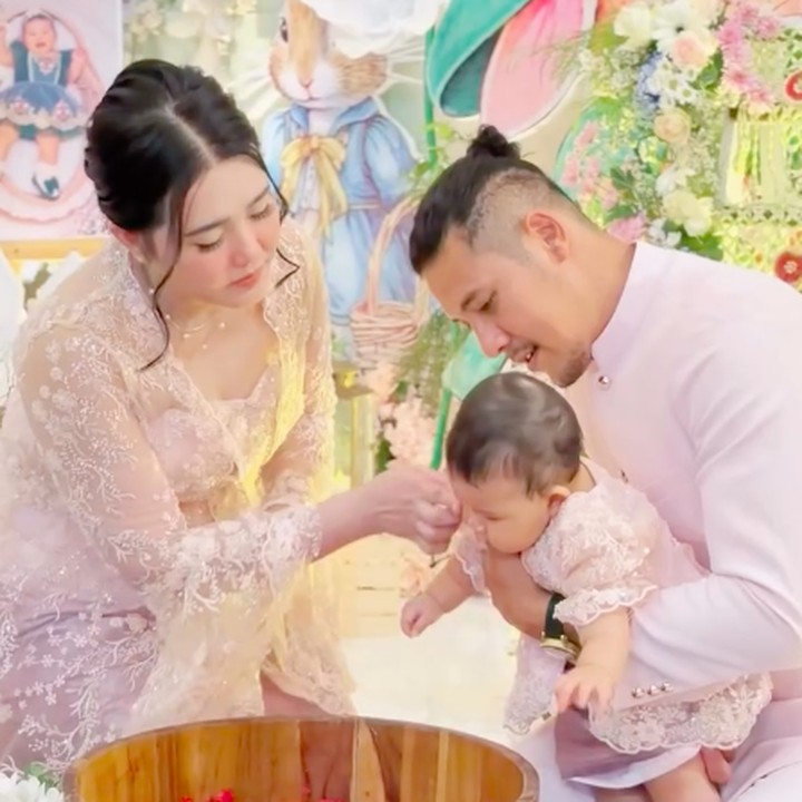 <p>Via Vallen dan suami beserta anak pertama mereka menjalani serangkaian prosesi dalam tedak siten. Salah satu prosesi adalah mencuci kaki anak dan membiarkan sang putri mengambil benda yang diletakkan di depannya. Perlu diketahui, tedak siten adalah tradisi adat Jawa saat anak menapakkan kaki ke tanah. Tradisi ini biasanya dilakukan saat anak berusia 7 hingga 8 bulan. (Foto: Instagram @viavallen)</p>