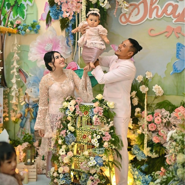 <p>Dalam acara tedak siten ini, Via Vallen mengenakan baju kebaya payet berwarna putih dengan sentuhan <em>peach</em> yang senada dengan baju putrinya Shazza. Sementara sang suami Chevra dan anak pertama mereka Agham, kompak memakai baju beskap berwarna putih. (Foto: Instagram @viavallen)</p>