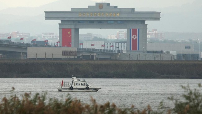 A China Immigration inspection vessel travels along the Yalu river past a North Korean customs building at the end of the newly opened New Yalu River Bridge, which connects North Korea's Sinuiju from China's Dandong New Zone, as seen from Dandong, Li