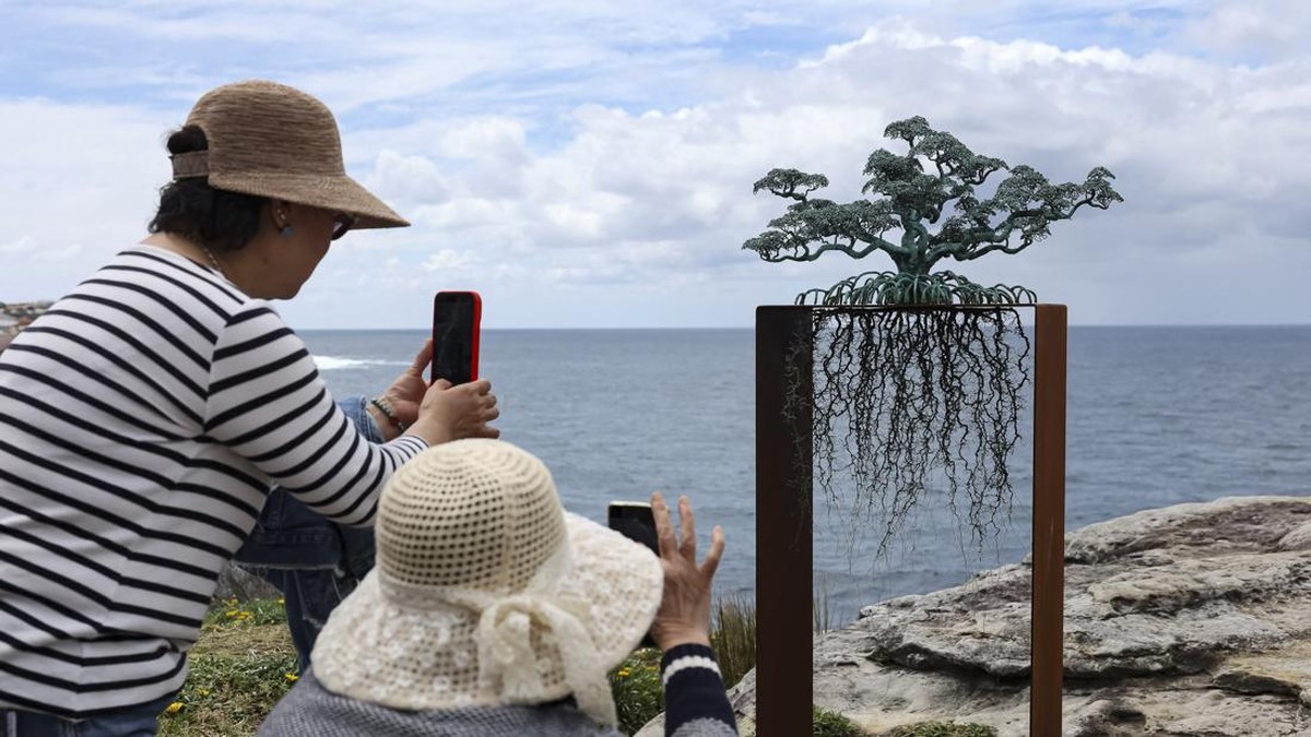 People takes photos of a sculpture titled The Guardians by artist Ulan & Rachel on the opening day of the 'Sculpture by the Sea' outdoor exhibition in Bondi, Sydney, Australia, October 16, 2026. REUTERS/Hollie Adams