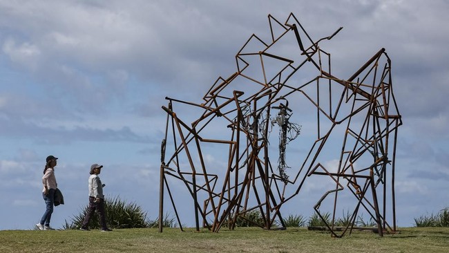 People walk past a sculpture titled Unveiling the Edges of the Sky by artist Harrie Fasher on the opening day of the 'Sculpture by the Sea' outdoor exhibition in Bondi, Sydney, Australia, October 16, 2026. REUTERS/Hollie Adams