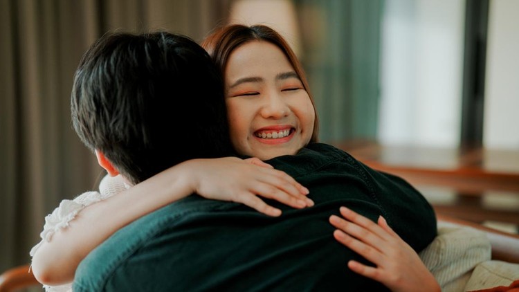 A young Asian man making up and hugging his girlfriend after an earlier argument&period;