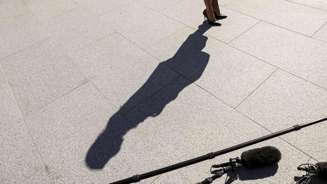 New White House Press Secretary Katie Zacharia casts a shadow as she listens to US President Donald Trump speaking to the media while departing the White House in Washington, DC, US, October 13, 2026.    REUTERS/Kevin Lamarque
