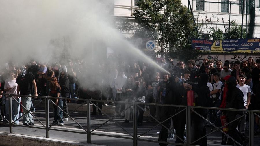 Seorang pengunjuk rasa yang mengenakan topeng menyemprotkan alat pemadam api di tengah bentrokan antara pengunjuk rasa dan polisi dalam sebuah aksi protes mahasiswa di Roma, Italia, pada 16 Oktober 2026.
