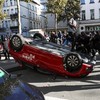 Demonstrators step onto an overturned car during a students' protest in Brussels, Belgium, October 17, 2026. REUTERS/Yves Herman