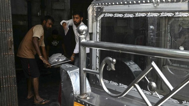 Medical staff carry the body of a victim killed in a stampede during a religious gathering, at a government mortuary in Kolkata on October 18, 2026. At least 17 people were killed and two dozen more injured on October 17 in eastern India after a stam