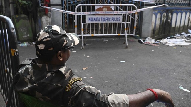 Police guard the exit point of the Chor Bagan Durga Puja pandal following a stampede which claimed more than 17 lives, leaving behind dozens injured, in Kolkata on October 18, 2026. At least 17 people were killed and two dozen more injured on October