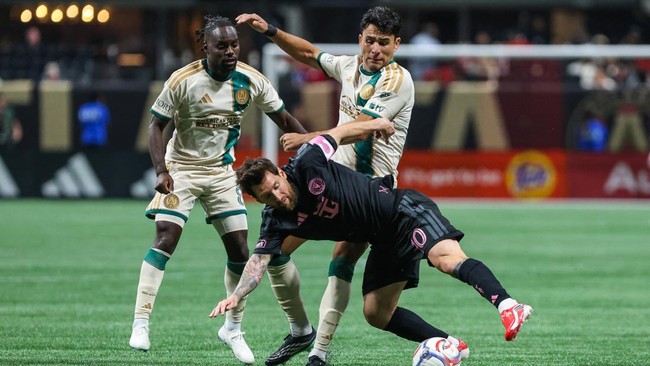 Oct 17, 2026; Atlanta, Georgia, USA;  Inter Miami CF forward Leo Messi (10) falls while defending the ball against Atlanta United midfielder Tristan Muyumba (8) and defender Junior Alonso (6) during the second half at Mercedes-Benz Stadium.  Mandator
