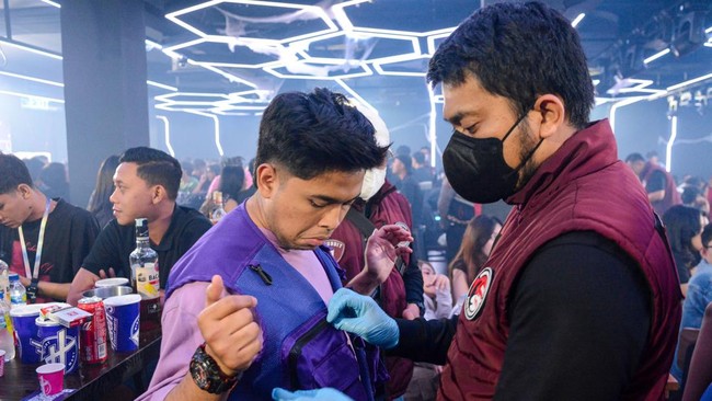 Petugas memeriksa pengunjung saat penggerebekan tempat hiburan malam di kawasan Cibubur, Jakarta, Minggu (18/10/2026). Sebanyak 462 personel gabungan dari Direktorat Tindak Pidana Narkoba Bareskrim Polri, Badan Narkotika Nasional (BNN) dan Polda Metr