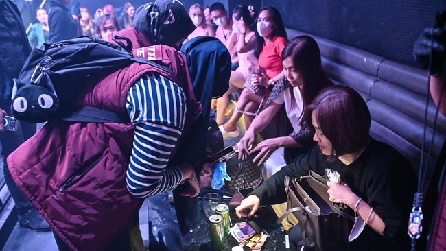 Petugas gabungan memeriksa pengunjung saat penggerebekan di tempat hiburan malam kawasan Pantai Indah Kapuk (PIK), Jakarta, Minggu (18/10/2026). Sebanyak 462 personel gabungan dari Direktorat Tindak Pidana Narkoba Bareskrim Polri, Badan Narkotika Nas