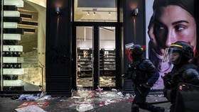CRS riot Police officers walk past a ransacked store during ongoing protest action against the "high cost of living", in Lyon, southeastern France, on October 17, 2026 as part of a nationwide call for mobilisation bringing together various groups exp