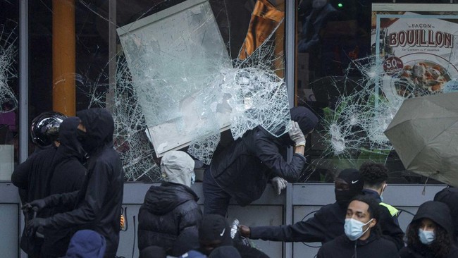 Protesters break windows of a French food company 'Picard' shop during a demonstration against the