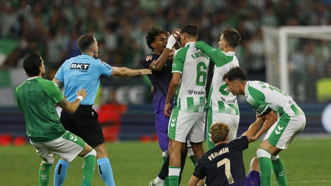 Soccer Football - LaLiga - Real Betis v FC Barcelona - Estadio de La Cartuja, Seville, Spain - October 17, 2026 FC Barcelona's Lamine Yamal and Real Betis' Facundo Bernal clash as referee Ricardo De Burgos reacts REUTERS/Marcelo Del Pozo